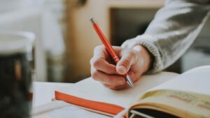 Persona escribiendo a mano su manifiesto de marca personal